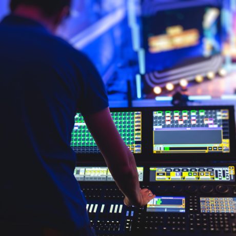 View of lighting technician operator working on mixing console workplace during live event concert on stage show broadcast, light mixer controller panel, sound technician with a professional equipment